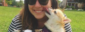 Close up shot of Kat Monusky of the Action Alliance holding her dogs, one of whom is licking her face.