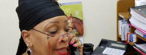 Photo of Charmaine Francois of the Action Alliance answering a phone.
