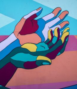Mural of two cupped colorful hands. Photo by Tim Mossholder on Unsplash.