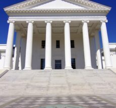 Head-on Image of the front of Virginia State Capitol with blue sky.
